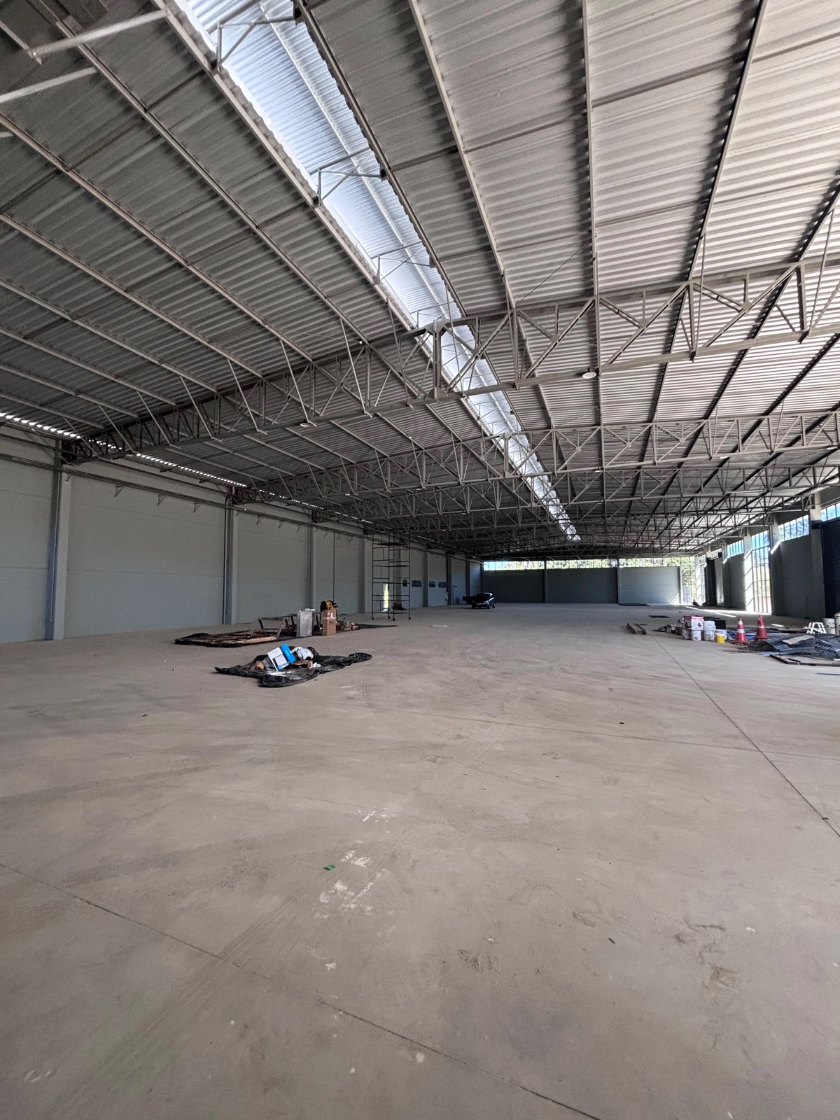 Interior amplo do galpão comercial com pé-direito alto e estrutura metálica aparente